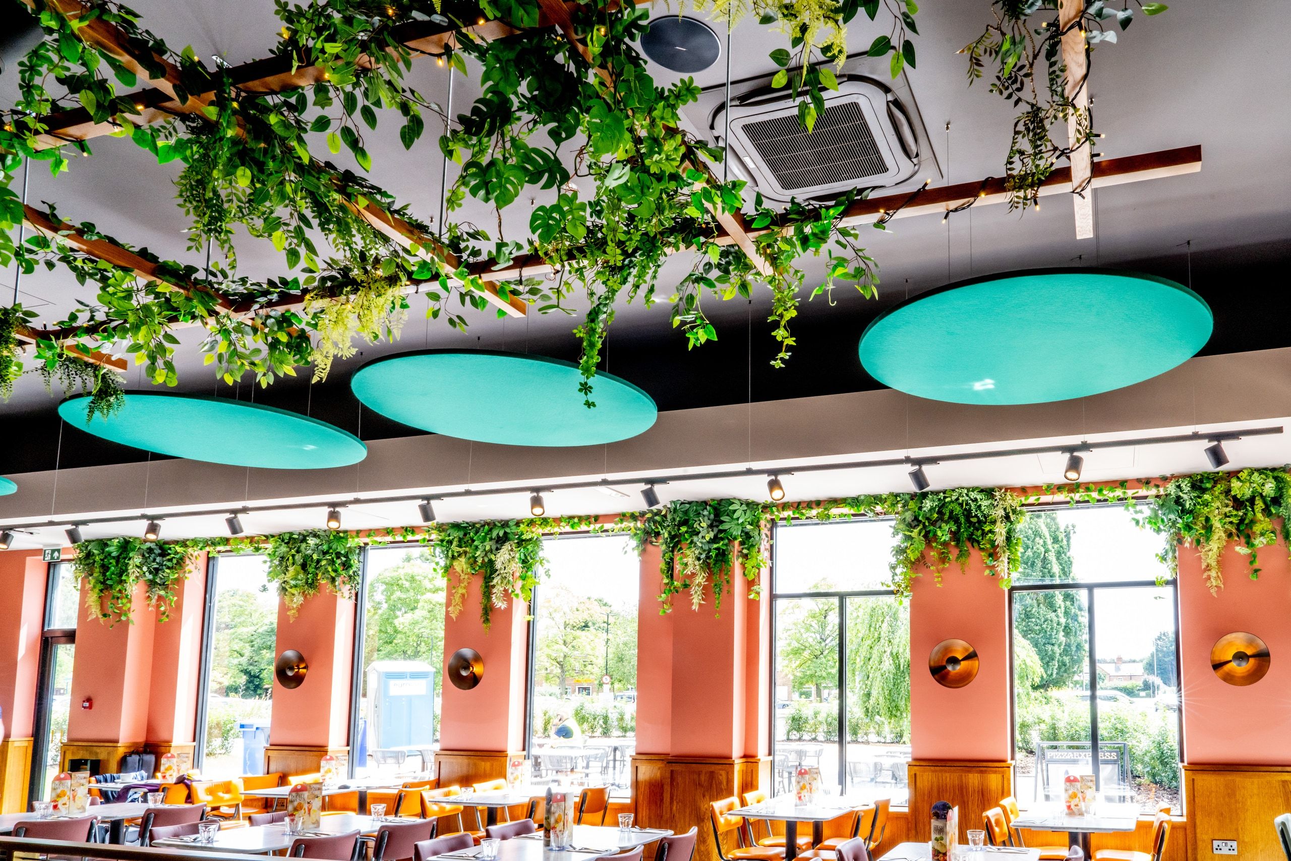 Feature ceiling rafts and planting installed around a recessed air conditioning cassette.