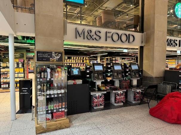 The M&S Food entrance and seating inside Paddington station.