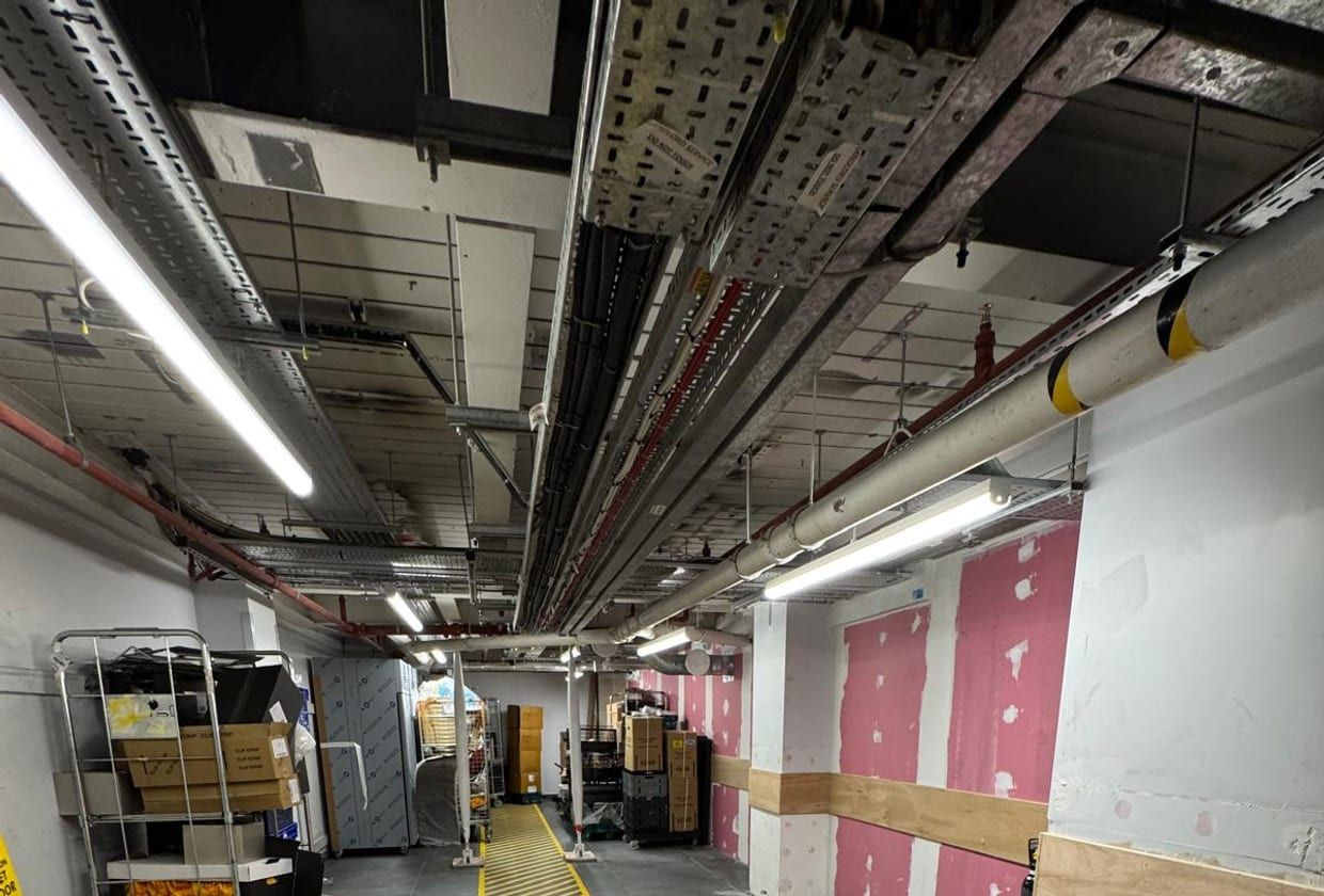 A clean, safety-marked back-of-house service route on a finished fit-out.